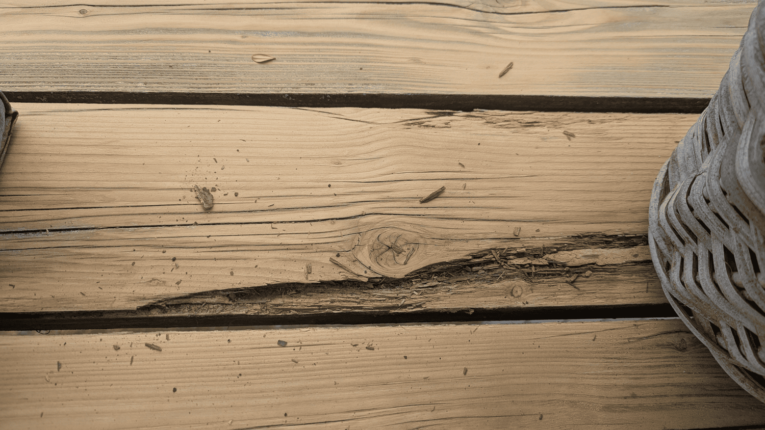 Stark geschädigte, morsche Holzterrassendiele mit Ausbruch im Faserverlauf als Reparaturfall für RENOVAID Holzsanierung