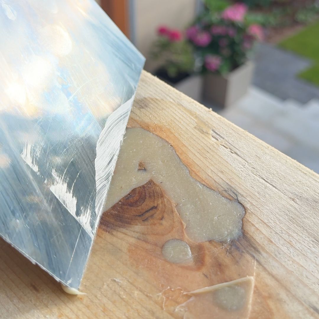 Ausgehärtetes Epoxidharz im Astloch mit Spachtel geglättet – Holzoberfläche für den Schliff vorbereitet