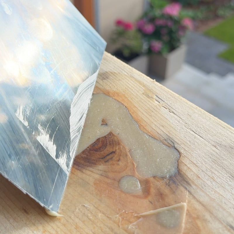 Ausgehärtetes Epoxidharz im Astloch mit Spachtel geglättet – Holzoberfläche für den Schliff vorbereitet
