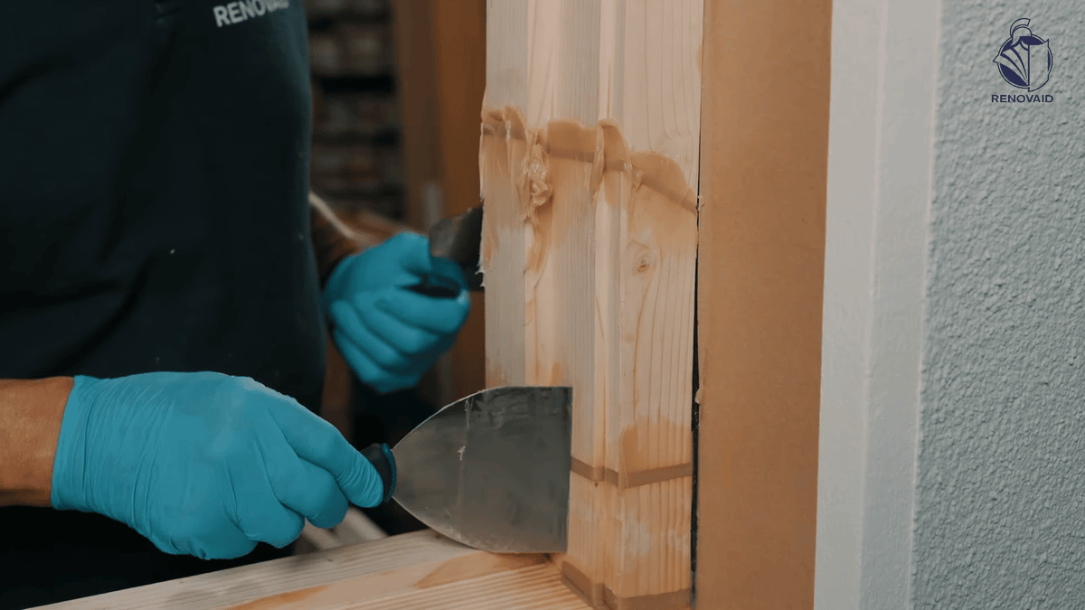 Holzreparaturmasse mit Spachtel in Schadstelle einarbeiten und leicht überstehend für bündiges Verschleifen abziehen