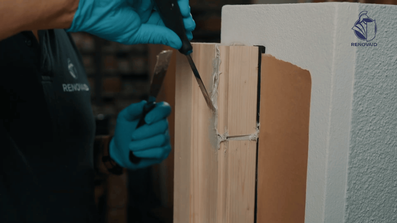 Modellieren und Glätten der Renofast Holzreparaturpaste an der Reparatur mithilfe von einem Spachtel.