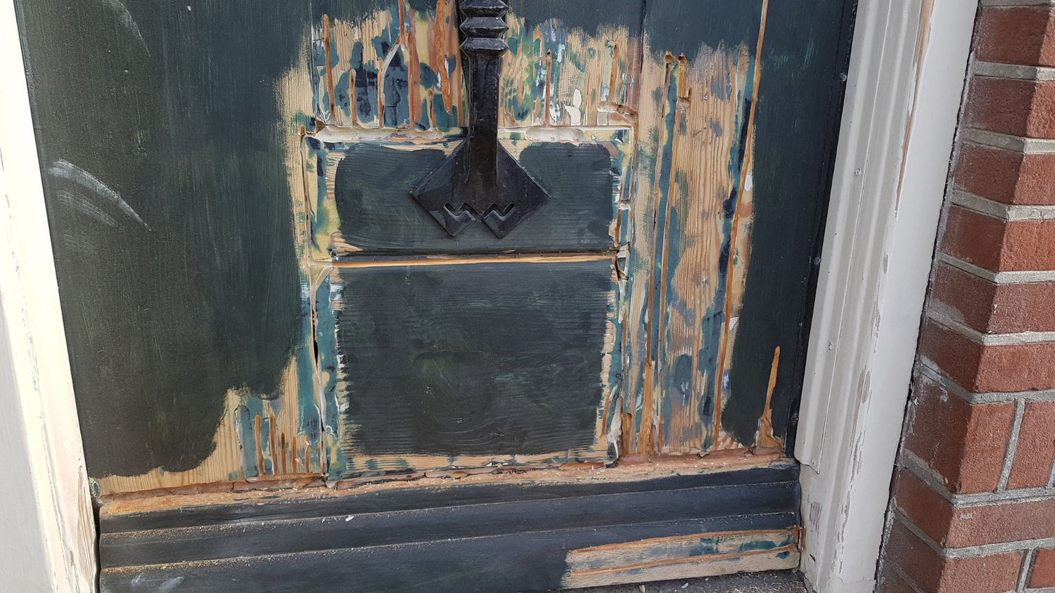 Holztür mit starken Rissen, offenen Fugen und Abplatzungen im unteren Bereich vor Reparatur mit RENOVAID Holzsanierung